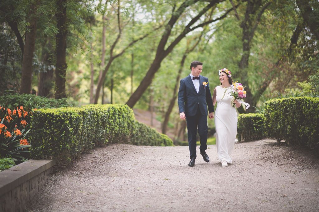 Brenton and Skye walking during wedding portraits Wilson Botanic Park